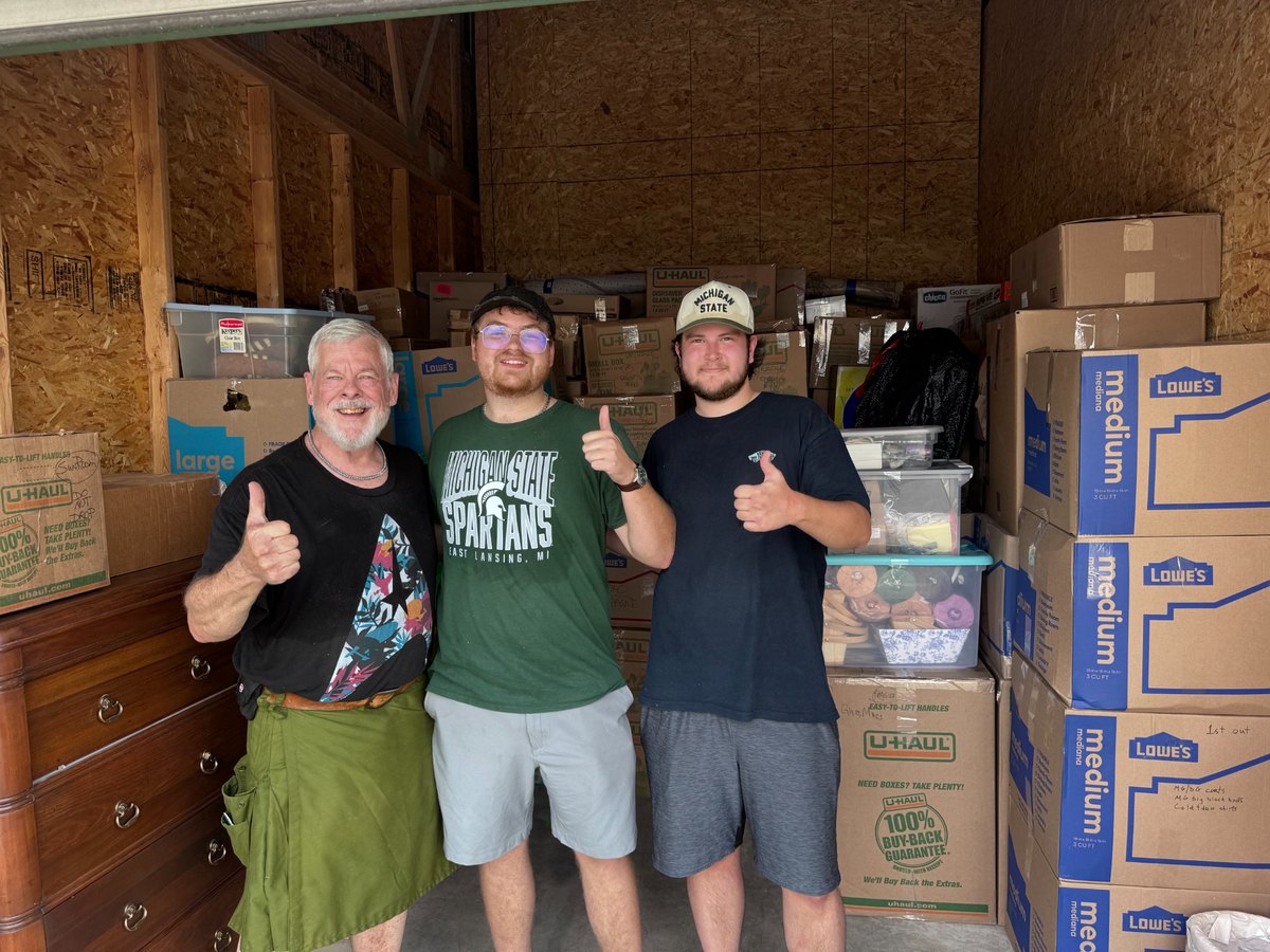 The Garage Sweepers with a customer inside a storage unit after loading boxes and furniture